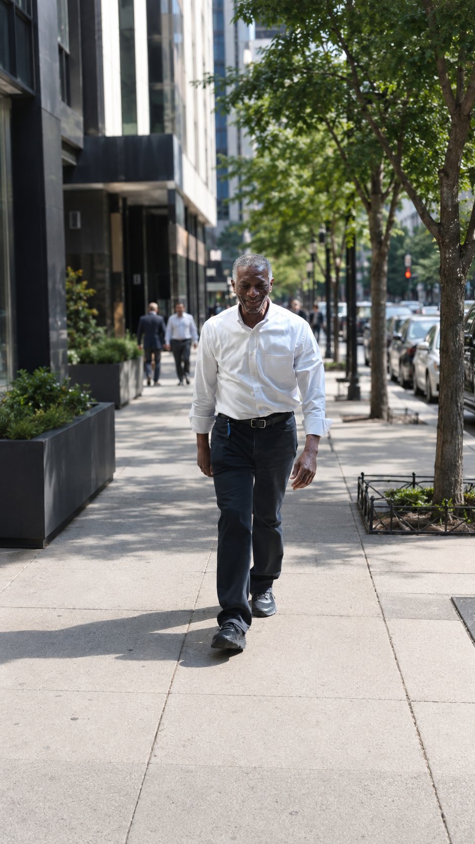 William Level walking a downtown sidewalk between calls, sleeves rolled, mid route.